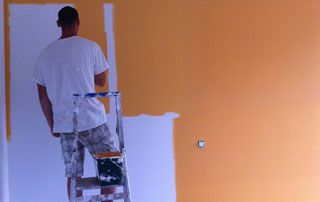 peintre au travail : peinture murale orange